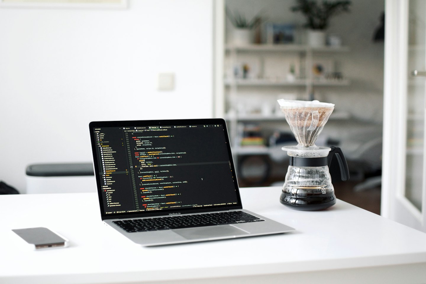 Un laptop con codice su una scrivania con una tazza di caffè.