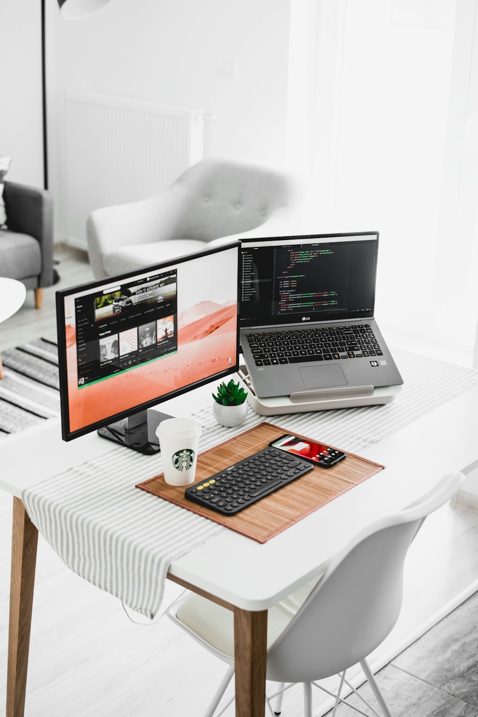 Ufficio moderno con laptop, monitor esterno con codice e accessori da scrivania.