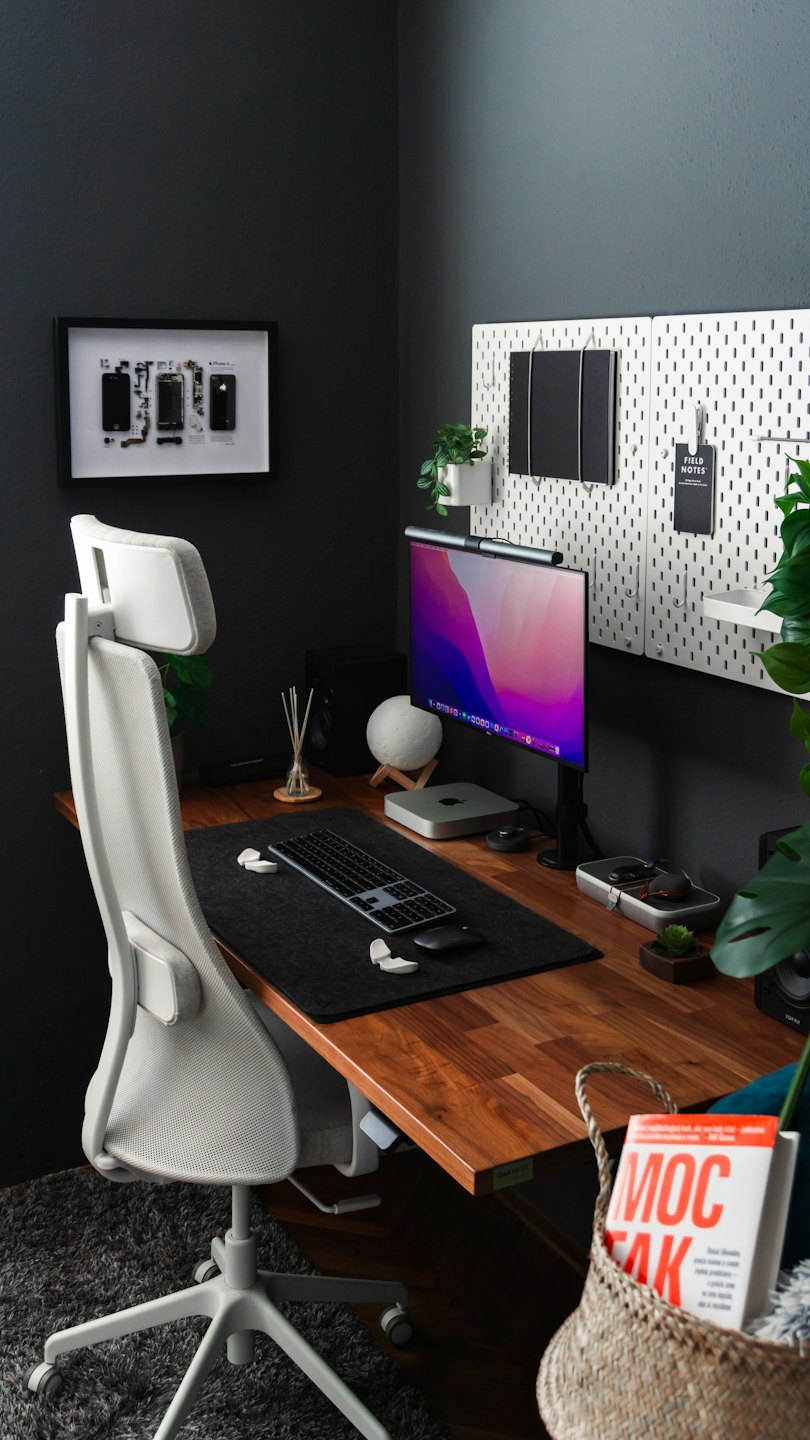 Una scrivania moderna con computer e piante.